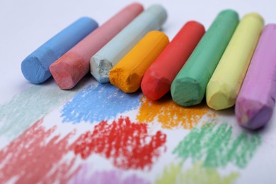 Colorful pastel chalks and scribbles on white background, closeup. Drawing materials