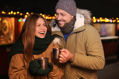 Happy couple with mulled wine at winter fair