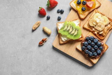 Flat lay composition with toast bread and different toppings on grey background