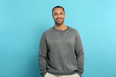 Photo of Portrait of handsome young man on light blue background