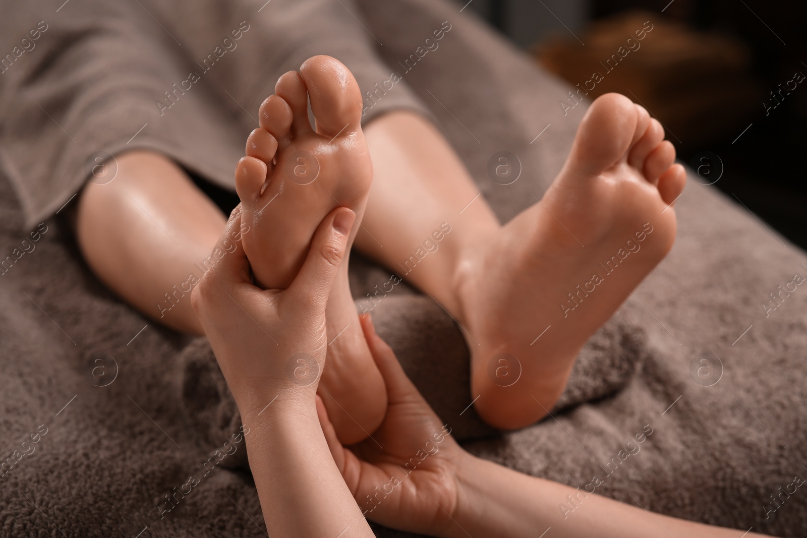 Photo of Woman receiving foot massage in spa salon, closeup