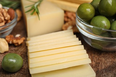 Photo of Snack set with delicious Parmesan cheese on wooden plate, closeup