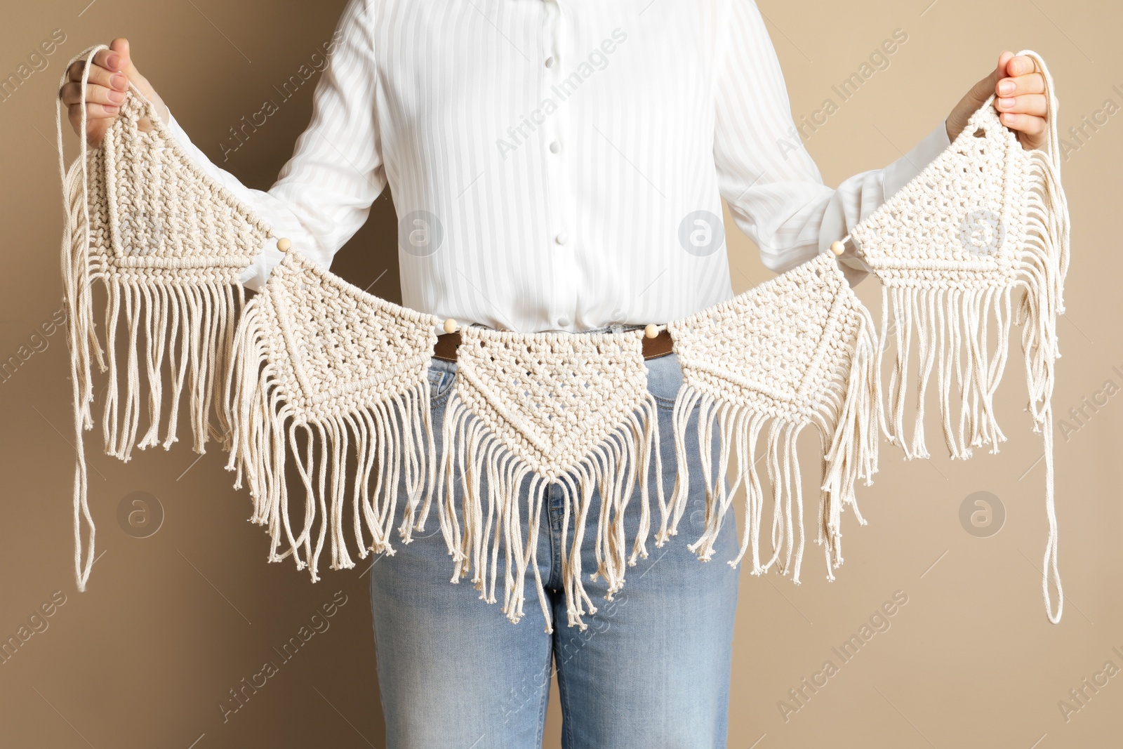 Photo of Woman holding large macrame on beige background, closeup