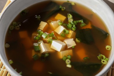Photo of Bowl of delicious miso soup with tofu, closeup