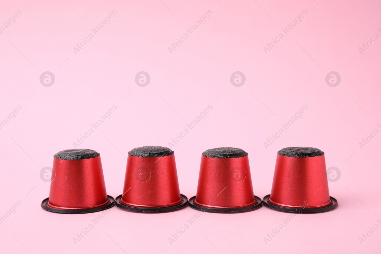 Photo of Many plastic coffee capsules on pink background