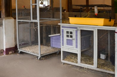 Empty metal cages with hay at farm