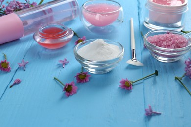 Photo of Homemade cosmetic products and fresh ingredients on light blue wooden table