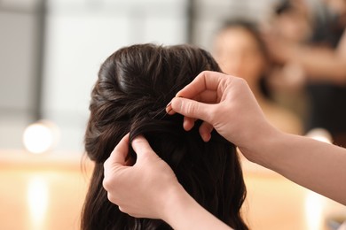 Photo of Hair styling. Professional hairdresser working with client indoors, closeup