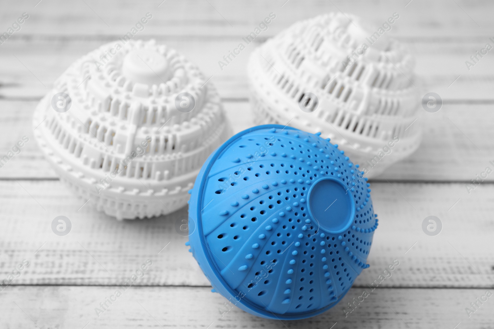 Photo of Dryer balls for washing machine on white wooden table. Laundry detergent substitute