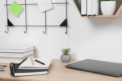 Photo of Home workspace. Laptop and stationery on wooden desk indoors