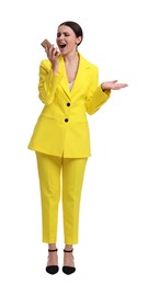 Beautiful emotional businesswoman in yellow suit using smartphone on white background