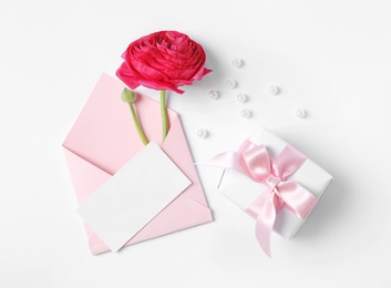 Photo of Composition with beautiful ranunculus flower and card on white background, top view. Space for text