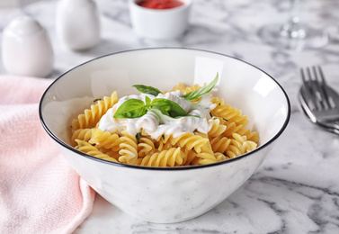 Photo of Delicious pasta with sauce served on white marble table