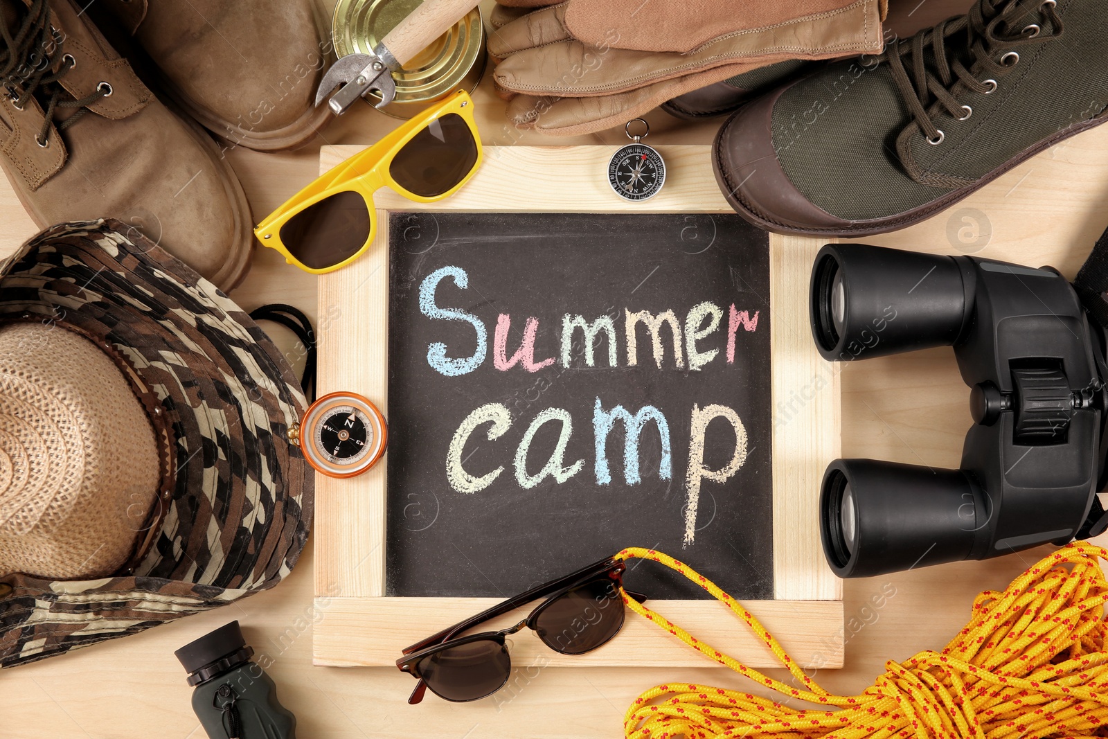 Photo of Flat lay composition with camping equipment on wooden background