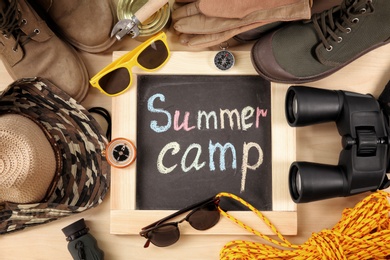 Photo of Flat lay composition with camping equipment on wooden background