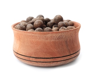 Photo of Wooden bowl with allspice on white background. Different spices