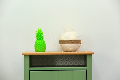 Photo of Stylish pineapple candle on table. Home decorating idea