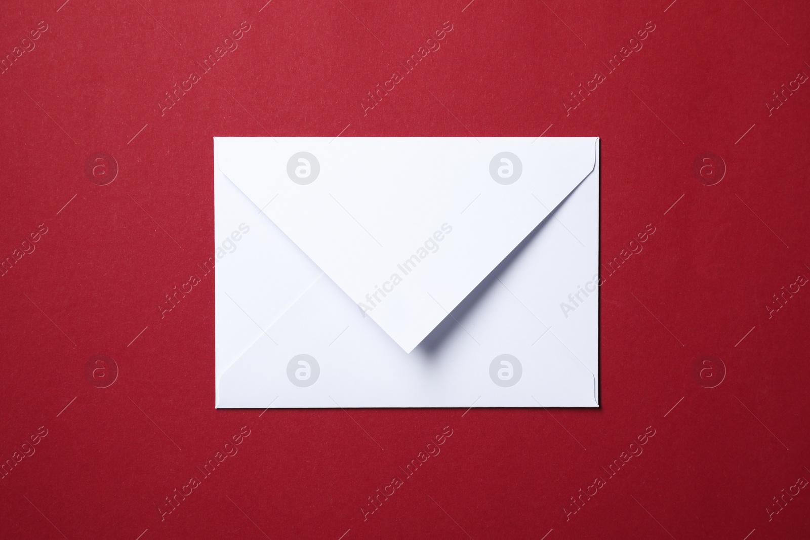 Photo of Letter envelope on red background, top view