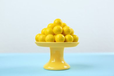 Photo of Delicious lemon chewing gums on light blue table