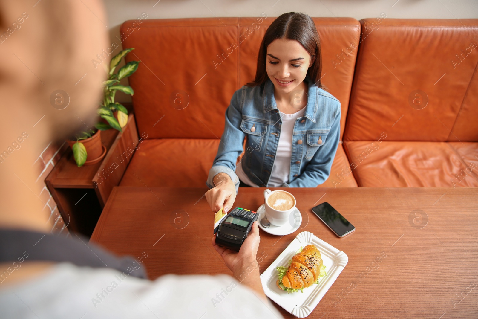 Photo of Woman using terminal for credit card payment in cafe