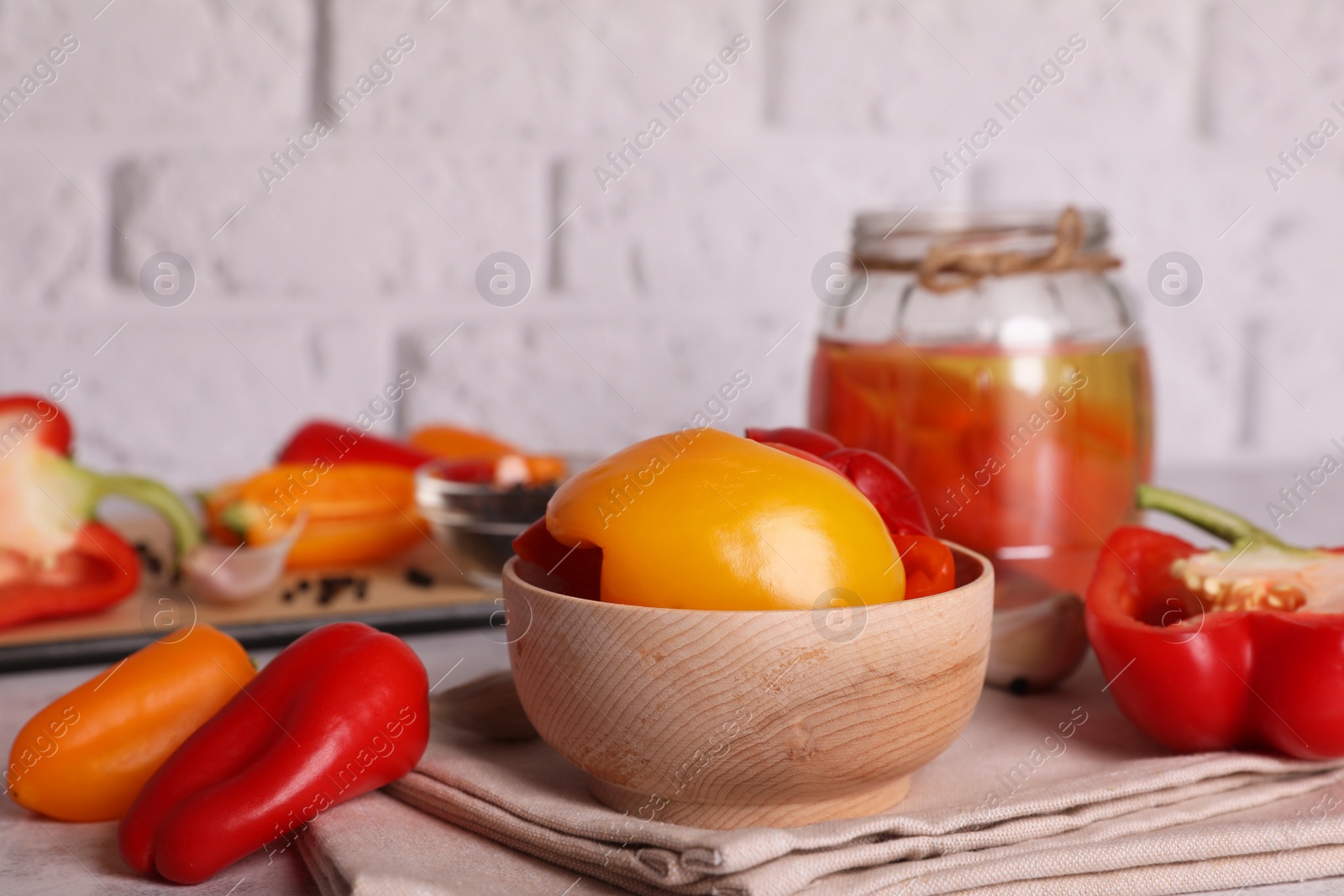 Photo of Tasty pickled peppers and fresh vegetables on table