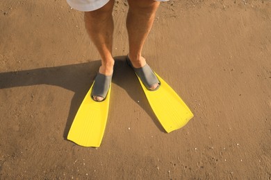 Photo of Man in flippers on wet sand, closeup