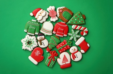 Photo of Different Christmas gingerbread cookies on green background, flat lay