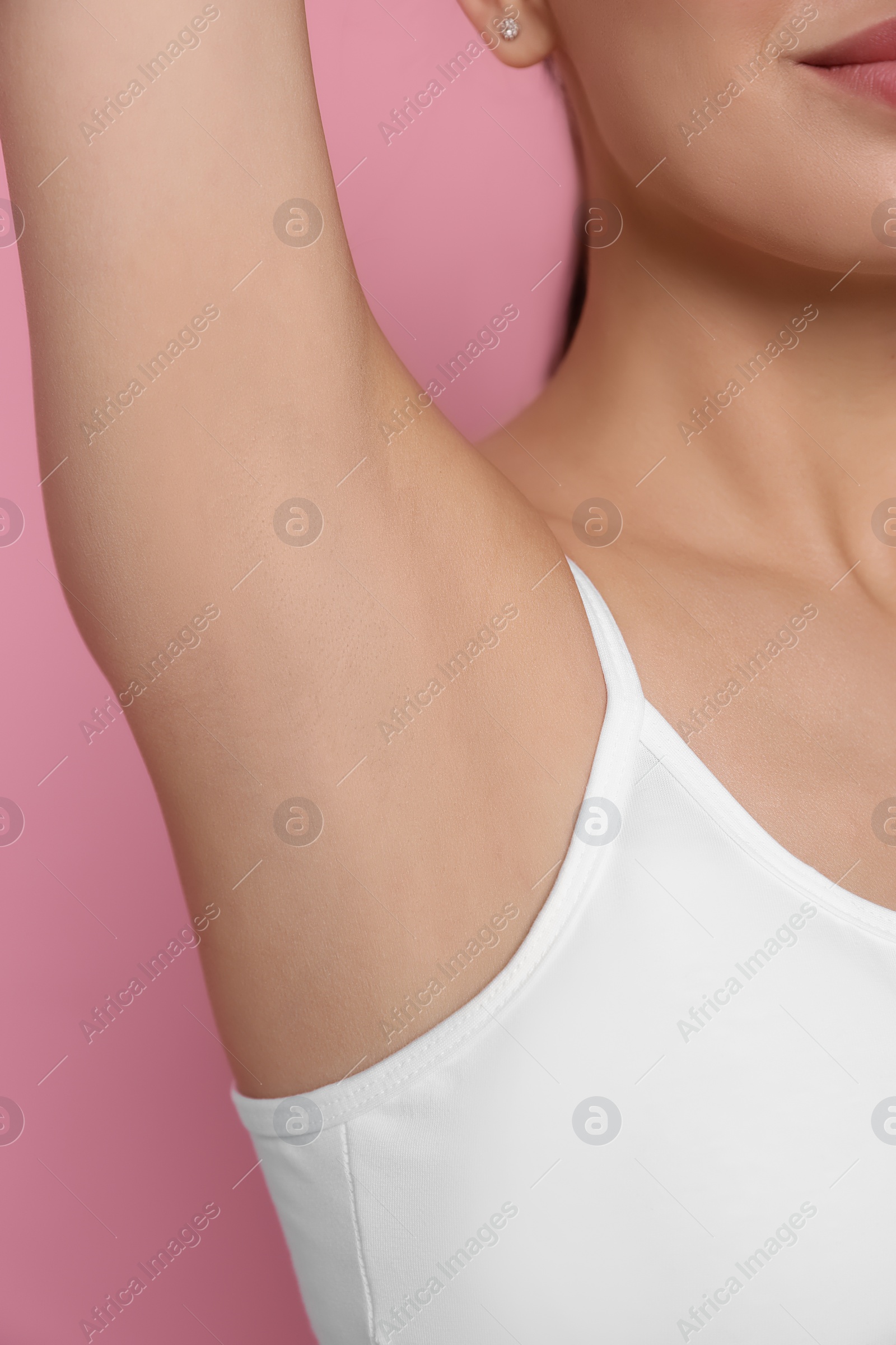 Photo of Young woman showing smooth skin after epilation on pink background, closeup