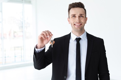 Photo of Male real estate agent with key indoors