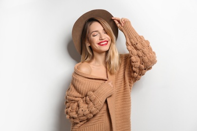 Photo of Beautiful young woman in warm sweater with hat on white background