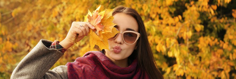 Image of Autumn walk. Young beautiful woman with leaves in park. Banner design