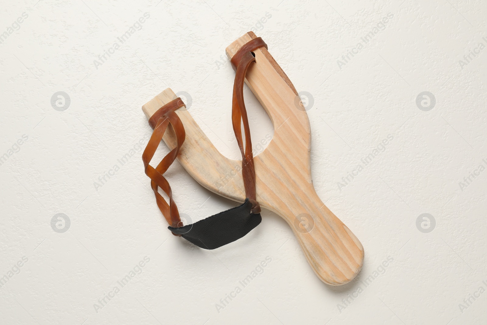 Photo of Slingshot with leather pouch on white background, top view