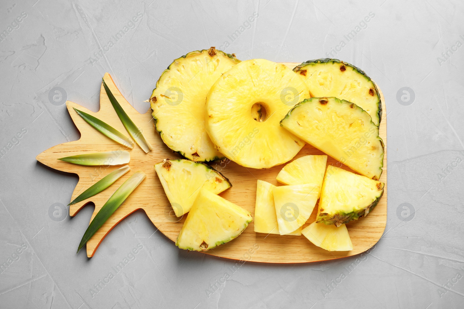 Photo of Flat lay composition with fresh sliced pineapple on gray background