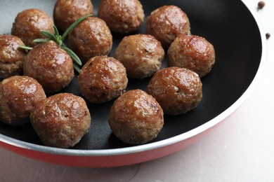 Photo of Tasty cooked meatballs on light grey marble table, closeup