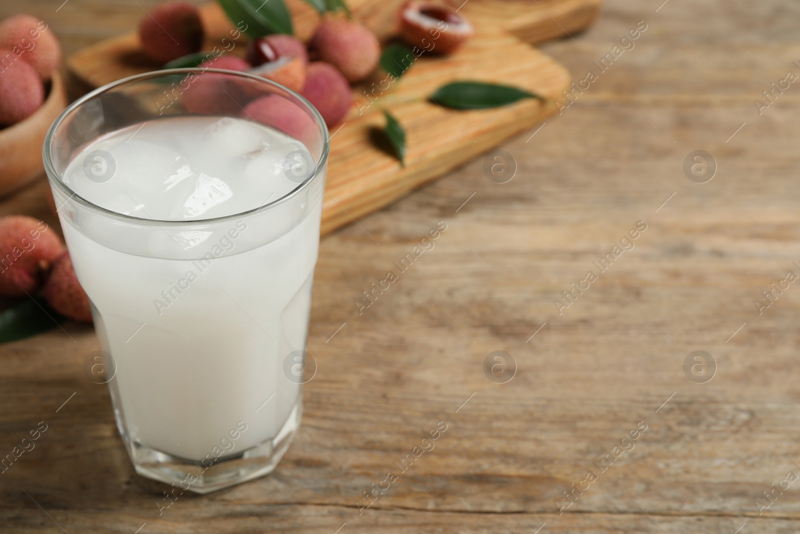 Photo of Fresh lychee juice on wooden table. Space for text