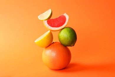 Photo of Fresh ripe citrus fruits on orange background