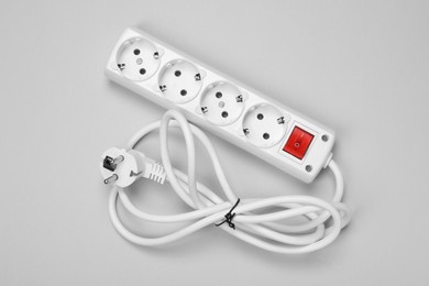 Photo of New power strip with switch button on white background, top view