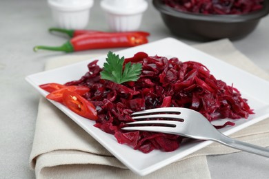 Photo of Tasty red cabbage sauerkraut served on light table, closeup