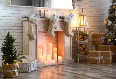 Photo of Stylish Christmas interior with decorative fireplace and burning candles