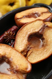 Tasty baked quinces with spices and honey in dish on table, closeup