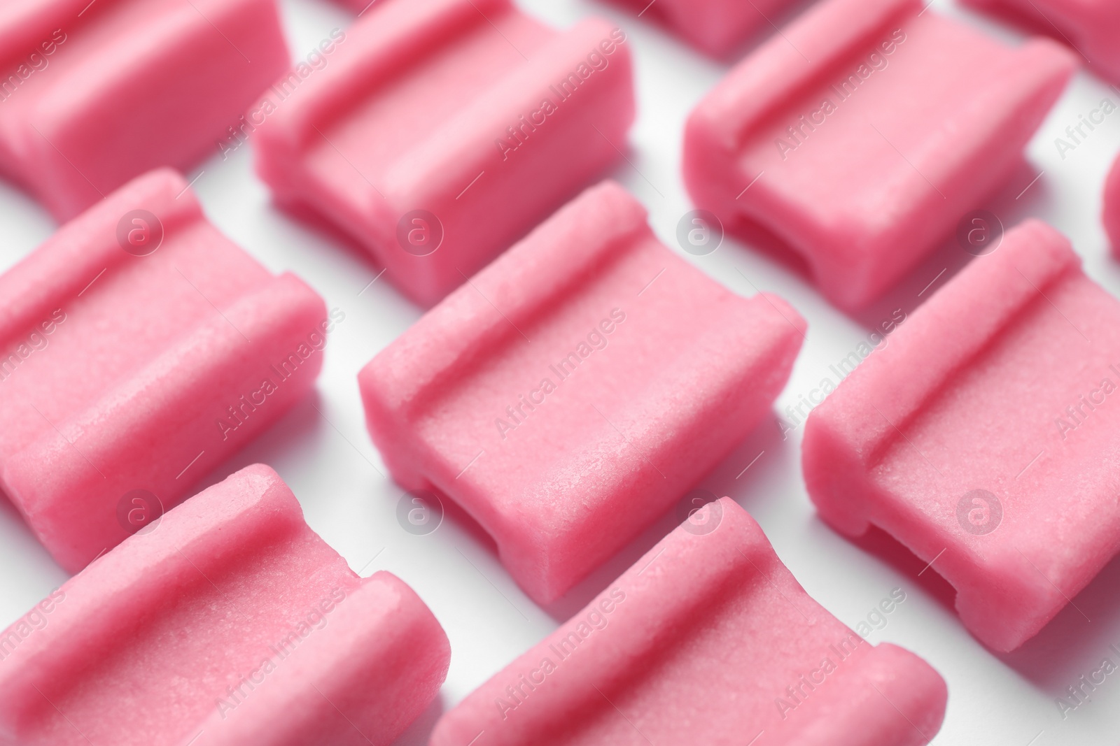 Photo of Tasty pink chewing gums on white background, closeup