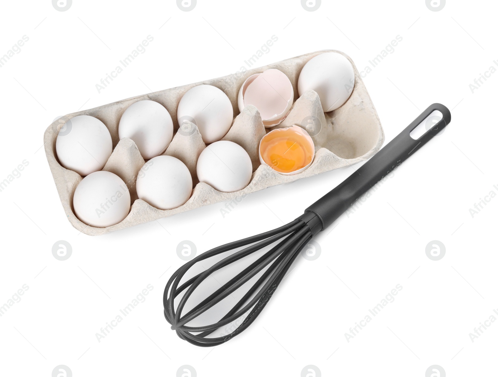 Photo of Whisk and carton with raw eggs isolated on white