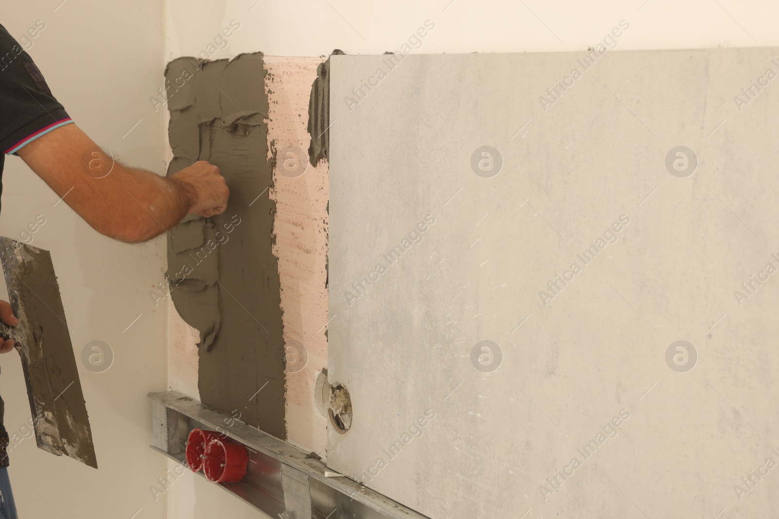 Photo of Worker installing tile in room, closeup. Home improvement