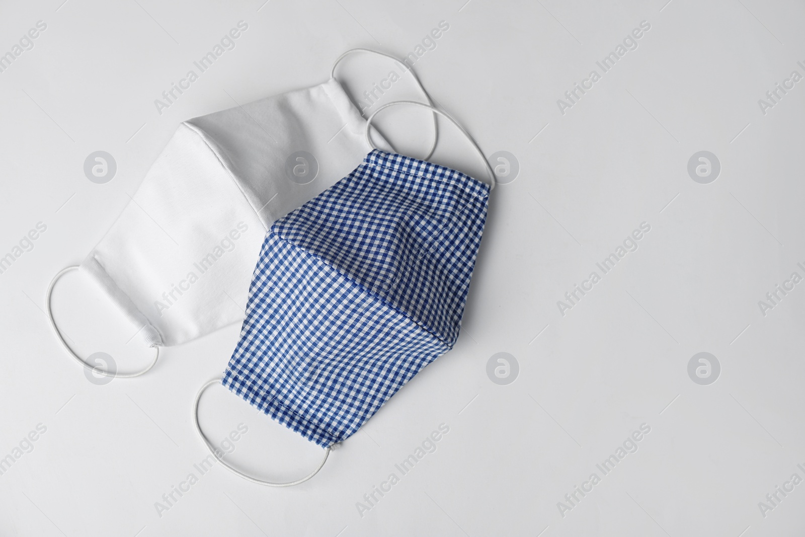 Photo of Homemade protective face masks on white background, top view. Space for text