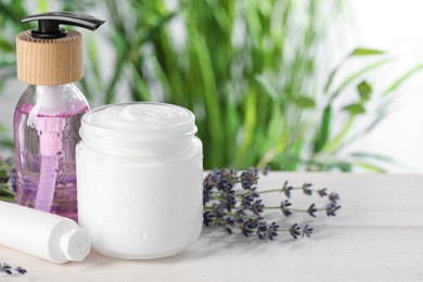 Photo of Different hand care cosmetic products and lavender flowers on white wooden table, space for text