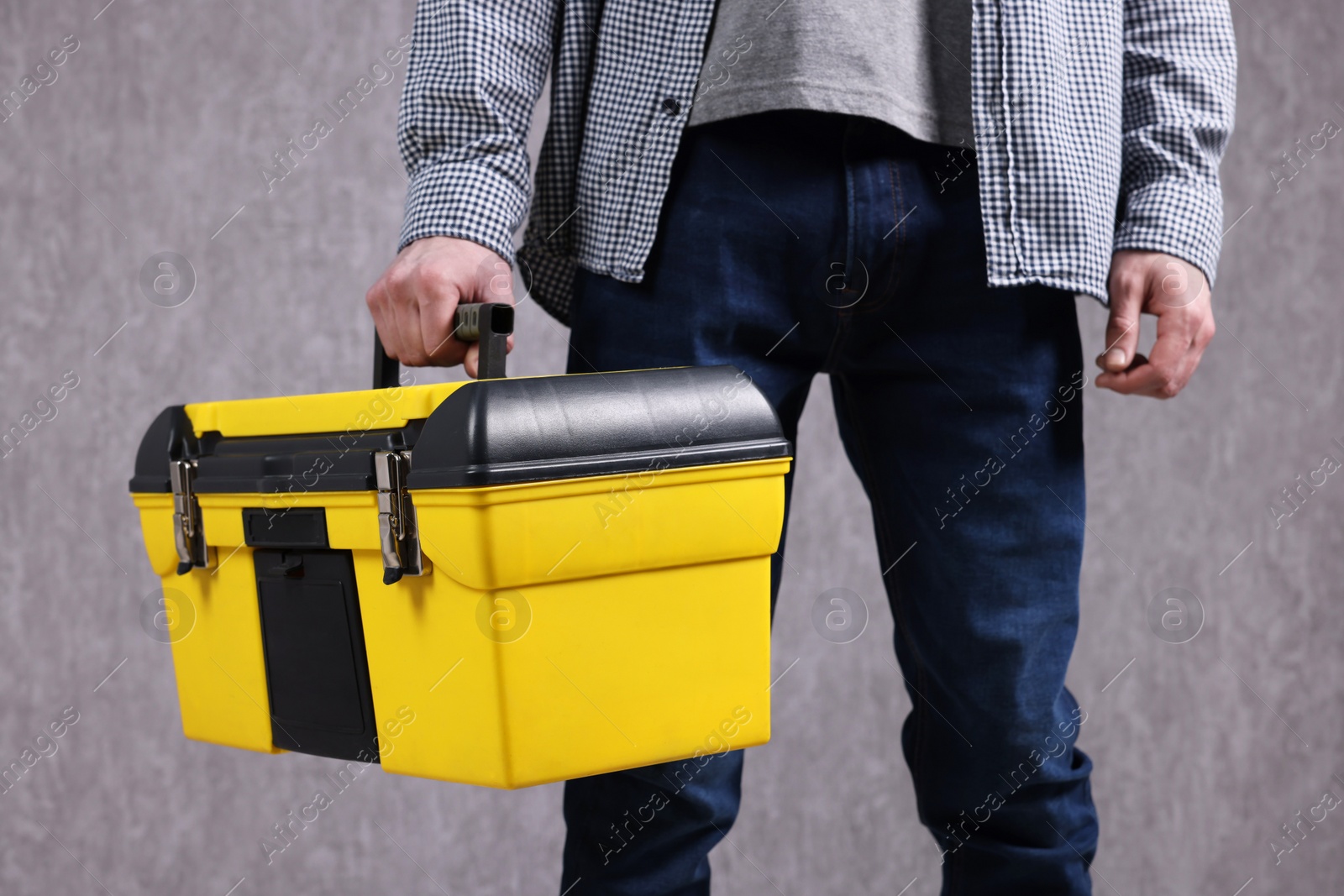 Photo of Young man with tool box on grey background, closeup