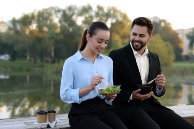 Photo of Smiling business people spending time together during lunch outdoors