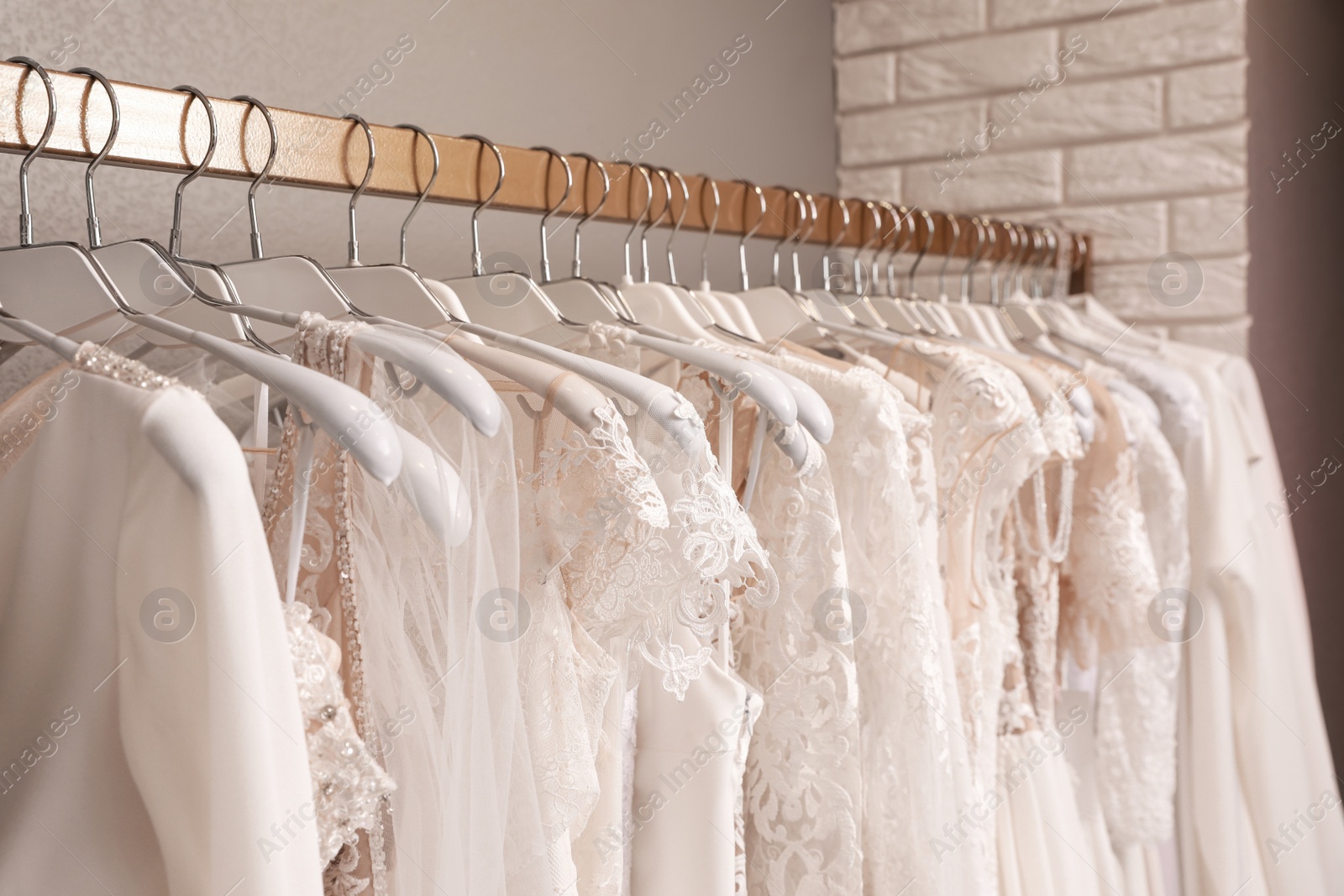 Photo of Different wedding dresses on hangers in boutique