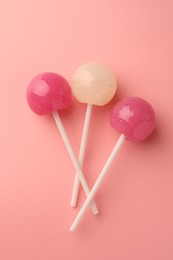 Tasty lollipops on pink background, flat lay