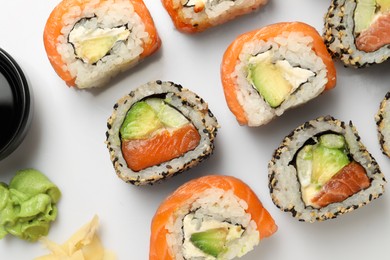 Delicious sushi rolls on white background, flat lay